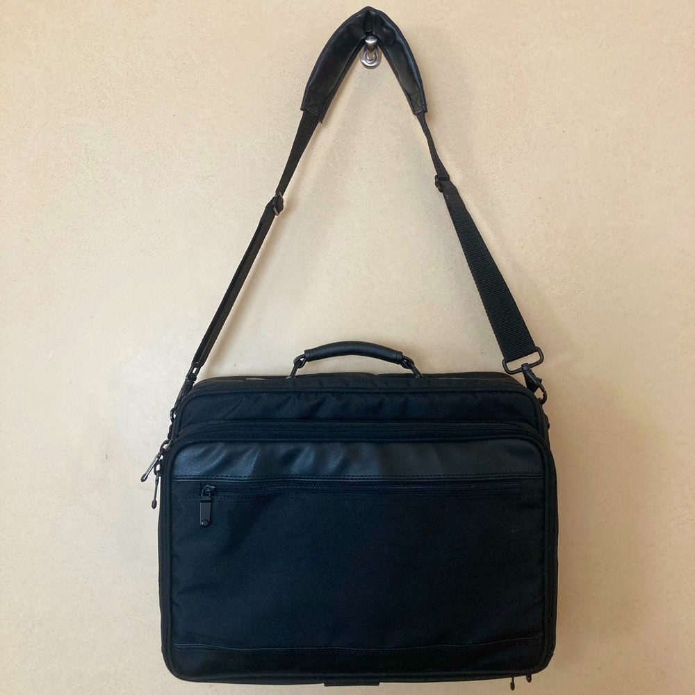 Gently used laptop bag in black nylon with several compartments.